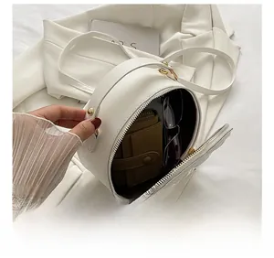 Interior view showing the storage capacity for wallet and sunglasses in white round bag
