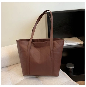 Detailed close-up of dark brown PU leather tote bag with geometric triangle quilted pattern