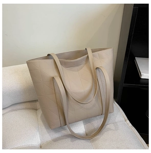 Close-up of beige geometric quilted PU leather tote bag with elegant triangle texture