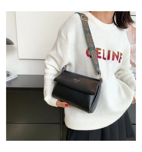 Détail du sac à bandoulière en cuir noir avec large sangle brodée au style ethnique