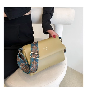Détail du sac bandoulière kaki avec une large sangle brodée au style ethnique coloré