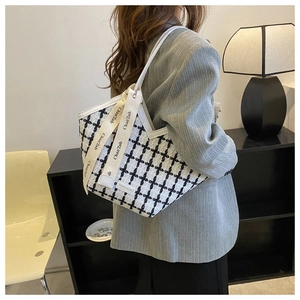 Detail of tweed tote bag with black and white plaid pattern and stylish ribbon strap