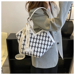 Detail of checkered tweed tote bag featuring V-cut design and chic decorative ribbon