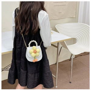 Détail du mini sac selle blanc pour enfants avec anse en perles et fleur 3D jaune