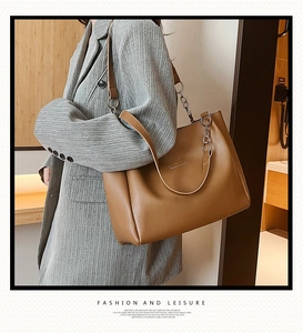 Vista dettagliata della borsa tote in pelle PU marrone con catena d'argento e logo su blazer