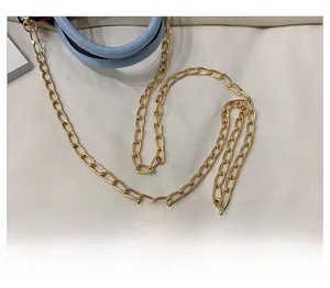Detailed close-up of a high-gloss golden alloy chain strap for a blue handbag