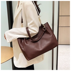 Dettaglio di una grande borsa tote in pelle PU marrone scuro con fibbie dorate