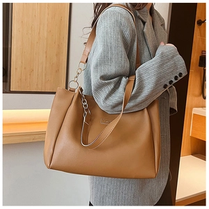 Dettaglio della borsa tote marrone in pelle PU con catena dorata e placca FASHION