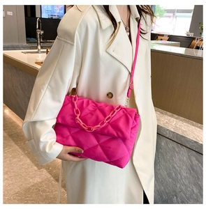 Gros plan détaillé du cabas matelassé rose fluo avec chaîne et coupe-vent beige