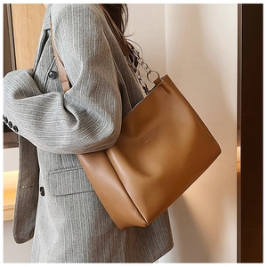 Dettaglio della borsa tote in PU cammello con etichetta, tracolla in pelle e catena oro