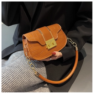 Détail du sac selle marron à motif crocodile avec boucle dorée et bandoulière