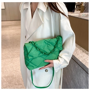 Détail d'un sac à bandoulière matelassé vert vif avec chaîne épaisse et tissu nylon