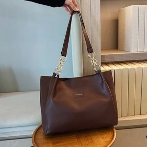 Dettaglio borsa tote in pelle PU marrone scuro con catena dorata e etichetta fashion