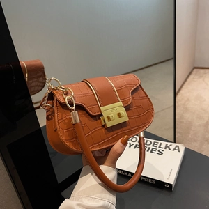 Détail du sac selle en similicuir crocodile caramel avec fermoir métallique doré