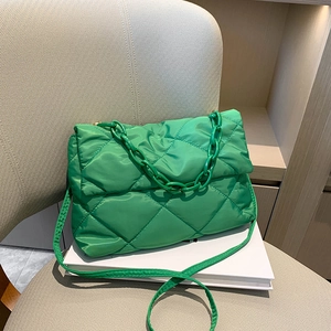 Détail d'un sac à épaule matelassé vert avec chaîne épaisse et bandoulière réglable