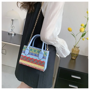 Close-up of geometric embroidered pattern and light blue leather detail on shoulder bag