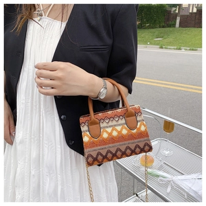 Detailed view of bohemian woven handbag with geometric patterns and gold chain strap