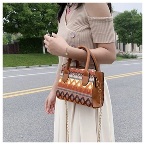 Detail of bohemian woven handbag featuring ethnic geometric patterns and leather trim