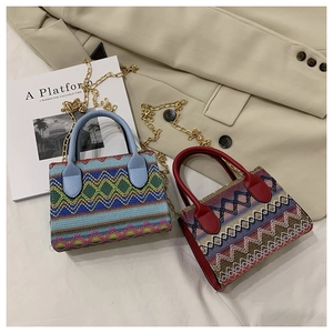 Detail of bohemian knit bags with geometric patterns and golden metal chain straps