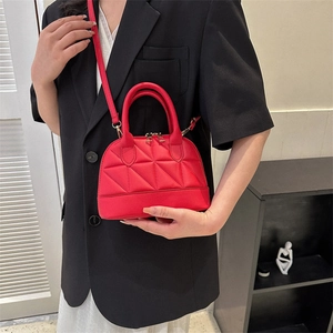 Red quilted shell crossbody bag with dual zippers shown in a stylish model photo