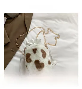 Detailed macro view of white plush bucket bag featuring brown heart-shaped cow pattern