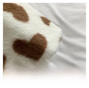 Close-up of soft cow-print plush bucket bag with brown heart patterns and fuzzy texture