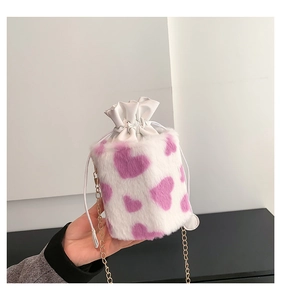 Detail of plush bucket bag with purple heart patterns and golden chain strap