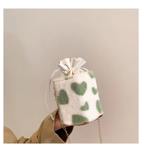 Detailed view of plush heart pattern bucket bag with gold chain and drawstring closure