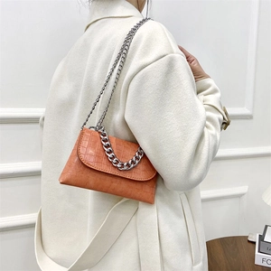 Chic orange crocodile pattern envelope bag with silver chain handle on model