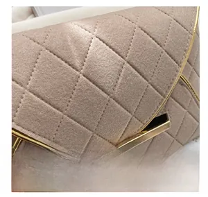 Gros plan sur le tissu en laine matelassé beige avec fermoir en métal doré de luxe