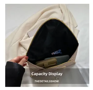 Vue intérieure d'une pochette beige matelassée montrant la grande capacité pour accessoires