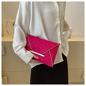 Détail de la pochette enveloppe matelassée fuchsia avec garniture dorée tenue par un mannequin