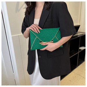 Détail de pochette enveloppe verte matelassée avec garniture dorée élégante et fermoir