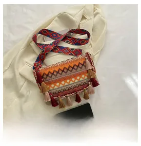 Close-up of bohemian woven crossbody bag with colorful tassels and geometric patterns