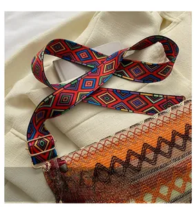 Detail of bohemian woven crossbody bag showing the colorful geometric wide strap and texture