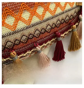Detailed macro view of geometric embroidery and colorful tassels on an ethnic shoulder bag