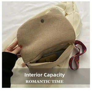 Internal view of straw woven crossbody bag showing capacity for phone and wallet with tassel