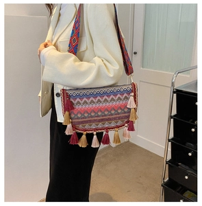 Detailed view of ethnic woven crossbody bag with colorful geometric patterns and tassels