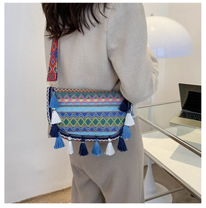 Close-up of ethnic style knitted crossbody bag with colorful geometric patterns and tassels