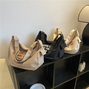 Three canvas crossbody bags with letter prints in khaki black and cream white colors