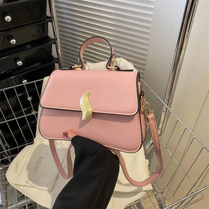 Sac bandoulière rose en cuir PU avec boucle dorée en forme de flamme dans un panier