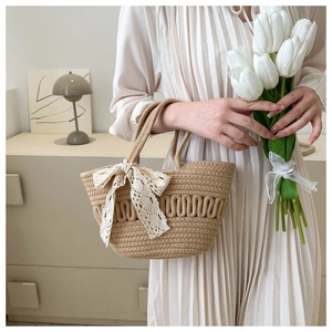 Detail of beige woven basket bag featuring soft lace bow and wavy rope texture