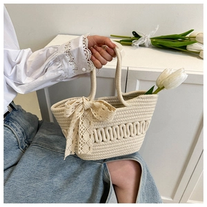 Detail of hand-woven straw bag with lace bow and elegant wavy woven texture