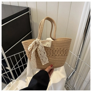 Close-up of beige woven basket bag with white lace bow and wavy texture details