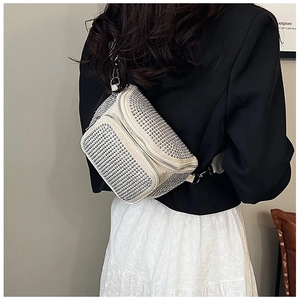 Detail view of beige crossbody bag with silver studs and double zipper design
