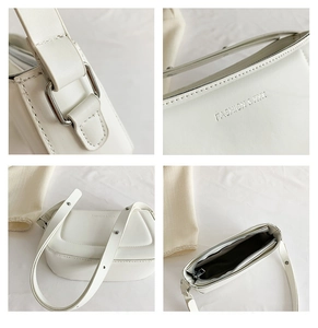 Detail view of white shoulder bag features rivet straps, zipper and embossed logo