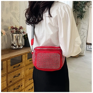 Sparkling red rhinestone crossbody bag with woven strap worn by a model in casual style