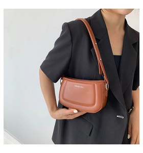 Detail of caramel leather shoulder bag with FASHION & RYX logo and adjustable strap