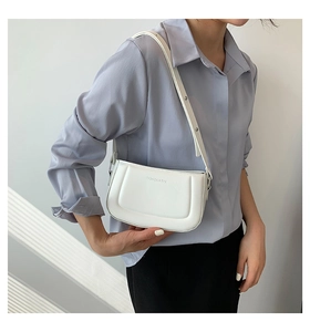 Detail of white minimalist faux leather shoulder bag with embossed fashion lettering