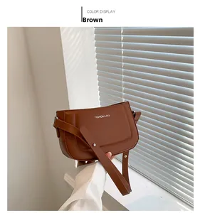 Detailed view of brown leather bag with silver Fashion & RYX logo and strap buckle